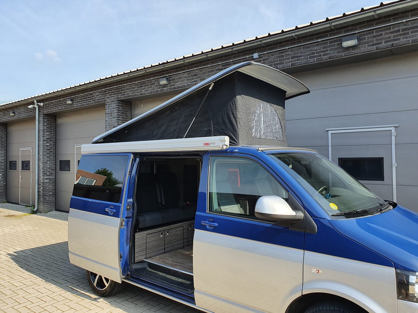 Zorgvuldig afgewerkt camperinterieur met keukenblok en zithoek