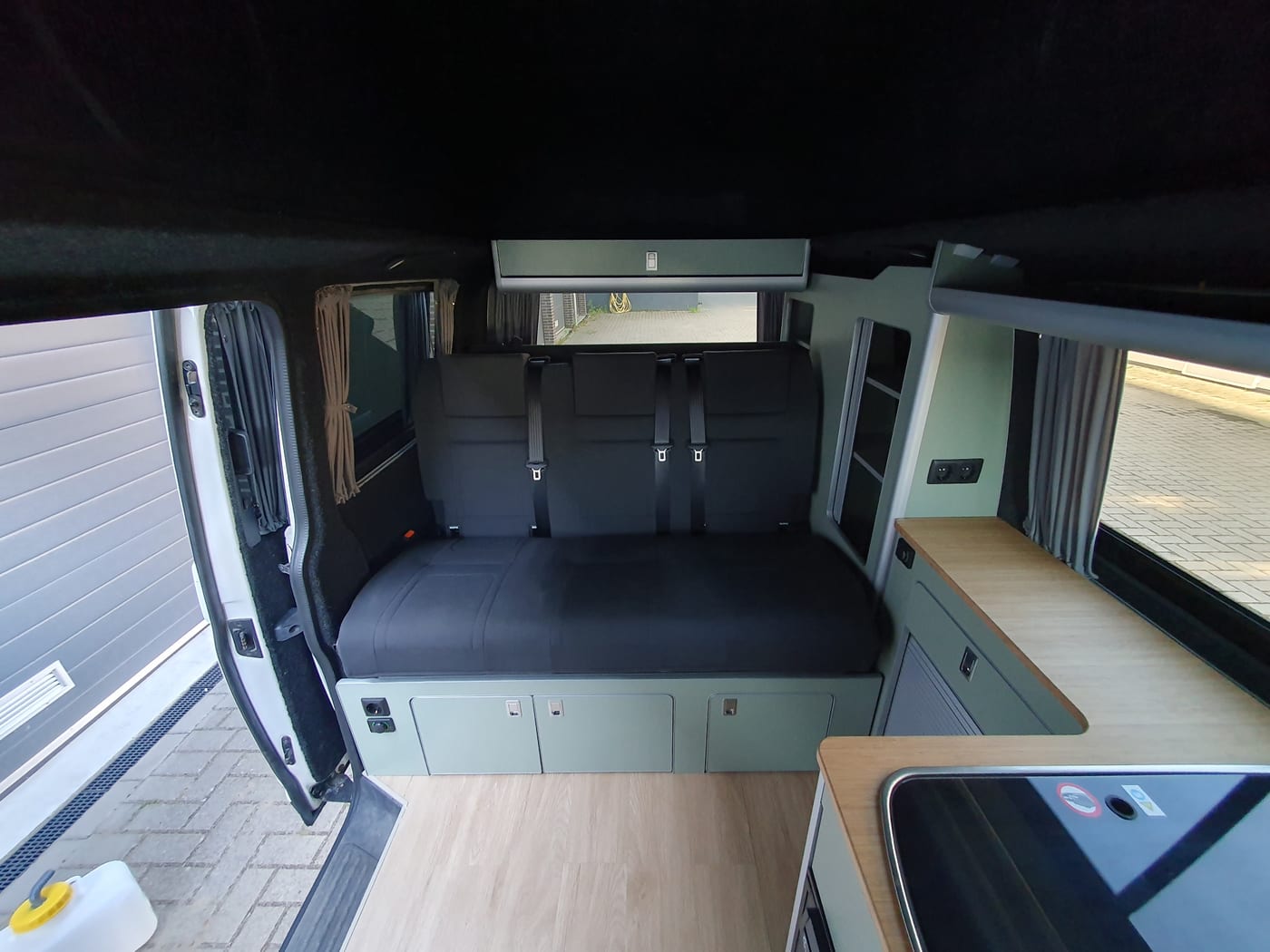 Compacte camperkeuken met tweepits gaskookstel en berkenhouten kastjes
